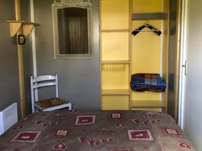 a bedroom with a bed and a yellow closet at Chalet PMR avec Terrasse pour 4 Pers, Roquefeuil - API-1-52-139 in Roquefeuil