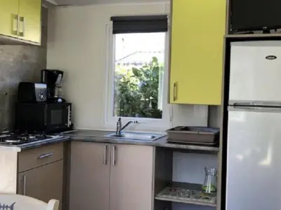 a small kitchen with a sink and a window at Mobil-home confort pour 4 personnes avec terrasse - API-1-52-115 in Roquefeuil