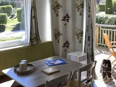 a table and chairs in a room with a window at Mobil-home confort pour 4 personnes avec terrasse - API-1-52-115 in Roquefeuil