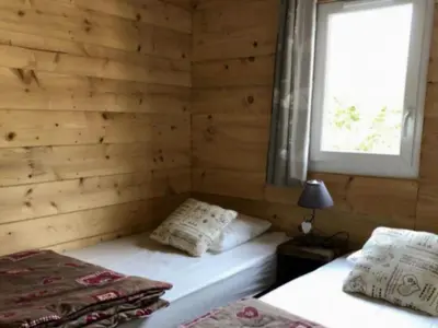 a room with two beds in a wooden wall at Chalet 4 pers avec terrasse à Roquefeuil - API-1-52-236 in Roquefeuil