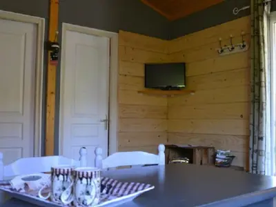 a dining room with a table and a tv on a wall at Chalet 4 pers avec terrasse à Roquefeuil - API-1-52-236 in Roquefeuil