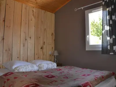 a bedroom with a bed with a wooden wall at Chalet 4 pers avec terrasse à Roquefeuil - API-1-52-236 in Roquefeuil