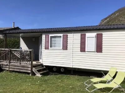 a mobile home with a porch and a house at Mobil home confortable avec 3 chambres et terrasse à Roquefeuil - API-1-52-142 in Roquefeuil