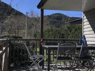 a table and chairs on a porch with a table and umbrella at Mobil home confortable avec 3 chambres et terrasse à Roquefeuil - API-1-52-142 in Roquefeuil