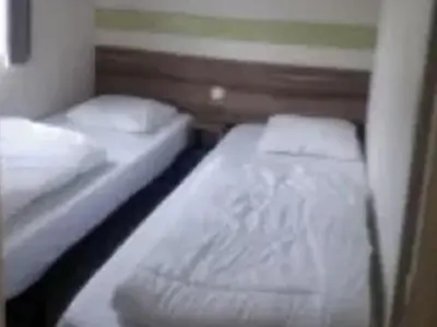 two twin beds in a small room with at Mobil-home 2 chambres avec terrasse à Vielmur-sur-Agout - API-1-52-1324 in Vielmur-sur-Agout