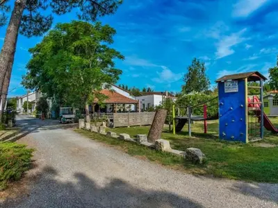 a playground with a blue building and a playground at Mobil-home 2 chambres avec terrasse à Vielmur-sur-Agout - API-1-52-1324 in Vielmur-sur-Agout