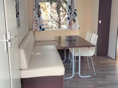 a small room with a table and a couch at Mobil-Home 2 Chambres avec Terrasse - API-1-52-1325 in Vielmur-sur-Agout
