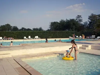 a woman playing with a child in a raft in a swimming pool at Mobil-Home 2 Chambres avec Terrasse - API-1-52-1325 in Vielmur-sur-Agout