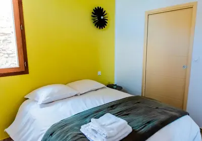 a bed with two pillows and a clock on the wall at Chai Chateau viticole avec piscine dans le sud de la France in Bélesta