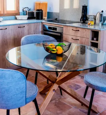 a glass table with a bowl of fruit on it in a kitchen at Chai Chateau viticole avec piscine dans le sud de la France in Bélesta