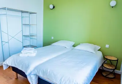 a bedroom with a large bed with white sheets at Chai Chateau viticole avec piscine dans le sud de la France in Bélesta