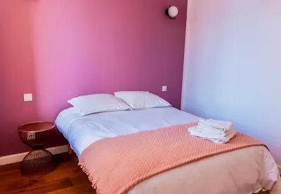 a bedroom with a bed with a pink wall at Chai Chateau viticole avec piscine dans le sud de la France in Bélesta