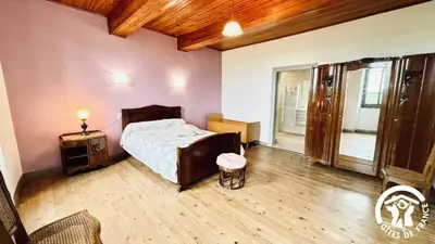 a bedroom with a bed and a wooden floor at Laguzou in Saint-Julien-de-Briola