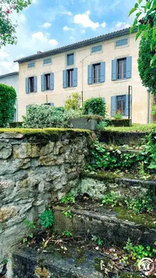 a stone wall in front of a building at Laguzou in Saint-Julien-de-Briola
