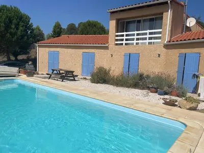 a swimming pool in front of a house at Maison idéalement située au milieu des vignes in Planèzes