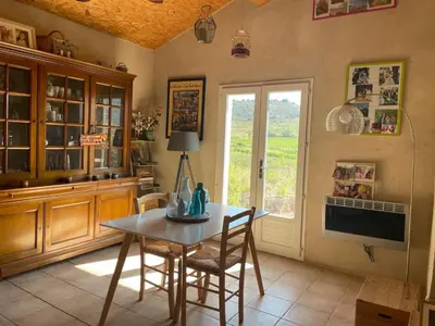 a dining room with a table and chairs and a window at Maison idéalement située au milieu des vignes in Planèzes