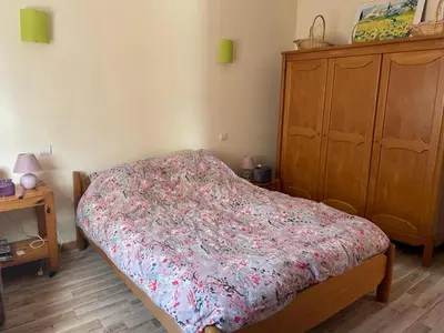 a bedroom with a bed and a wooden dresser at Maison idéalement située au milieu des vignes in Planèzes