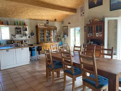 a kitchen and dining room with a wooden table and chairs at Maison idéalement située au milieu des vignes in Planèzes