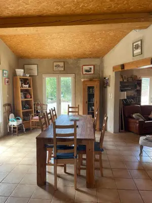 a dining room with a wooden table and chairs at Maison idéalement située au milieu des vignes in Planèzes