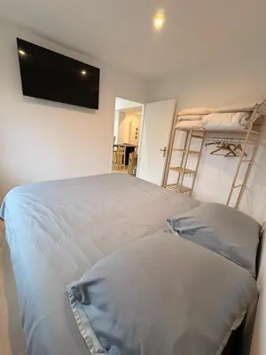 a bedroom with two bunk beds and a flat screen tv at Charmant T2 au cœur de ville in Narbonne