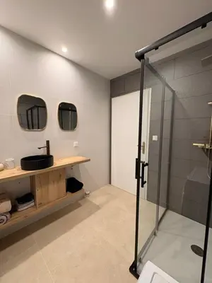 a bathroom with a glass shower and a sink at Charmant T2 au cœur de ville in Narbonne