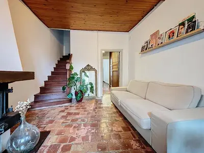 a living room with a couch and a staircase at Le Triplex - Spacieux appartement proche de la mer in Sigean