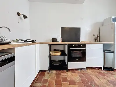 a kitchen with white cabinets and a counter with a dishwasher at Le Triplex - Spacieux appartement proche de la mer in Sigean
