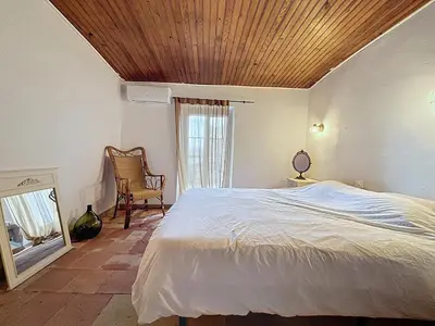 a bedroom with a bed with a wooden ceiling at Le Triplex - Spacieux appartement proche de la mer in Sigean