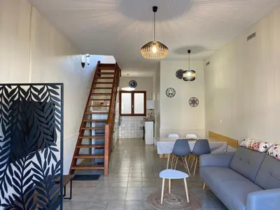 a living room with a couch and a staircase at Maison village Aude Pays Cathare in Granès