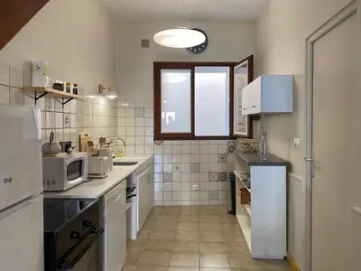 a small kitchen with white appliances and a window at Maison village Aude Pays Cathare in Granès