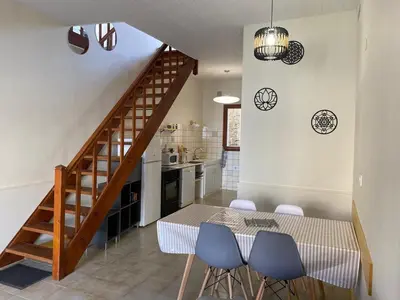 a kitchen and dining room with a table and blue chairs at Maison village Aude Pays Cathare in Granès