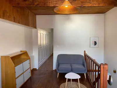 a living room with a blue chair and a staircase at Maison village Aude Pays Cathare in Granès