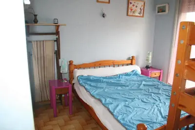 a bedroom with a bed with a blue blanket at Port La Nouvelle T2 rez de chaussée idéal pour 4 personnes in Port-la-Nouvelle