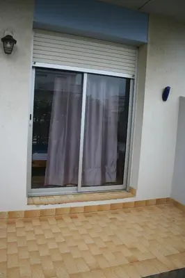 a window with purple curtains in a house at Port La Nouvelle T2 rez de chaussée idéal pour 4 personnes in Port-la-Nouvelle