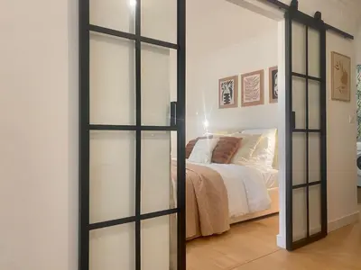 a sliding glass door in a bedroom with a bed at Peaceful & Elegant Retreat in the heart of town in Carcassonne