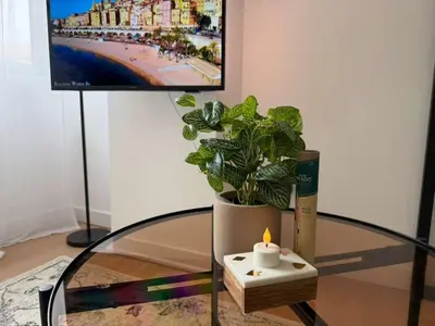 a table with a candle and a potted plant at Peaceful & Elegant Retreat in the heart of town in Carcassonne