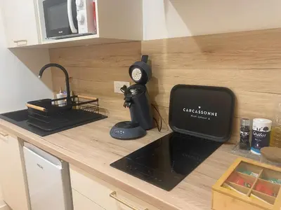 a kitchen counter with a microwave and a clock on it at Peaceful & Elegant Retreat in the heart of town in Carcassonne