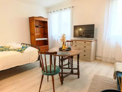 a bedroom with a table and a bed and a television at LE COSY - Studio 4 pers - wifi - centre ville in Limoux