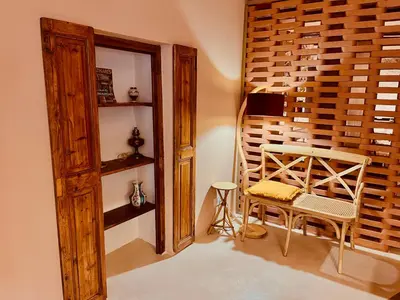 a room with a wooden wall and a table and a chair at Escapade Troglodyte in Fitou