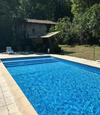 a large blue swimming pool in front of a house at Old Farmhouse Surrounded By Nature In Sidobre in Burlats