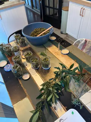 a table with a bowl and jars of olives on it at La Pause Bonheur in Luc-sur-Orbieu