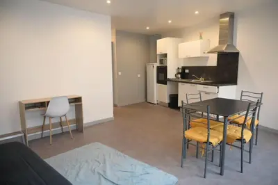 a living room with a table and chairs and a kitchen at Le Nid Central - Lumineux et confort, cœur Mazamet in Mazamet