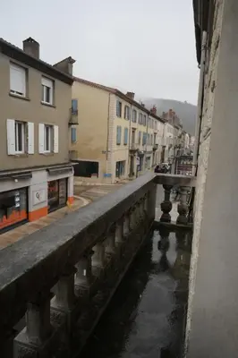 a bridge over a river in a city with buildings at Le Nid Central - Lumineux et confort, cœur Mazamet in Mazamet
