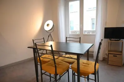 a dining room with a table and chairs and a television at Le Nid Central - Lumineux et confort, cœur Mazamet in Mazamet