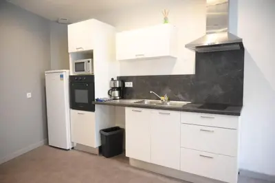 a white kitchen with a sink and a refrigerator at Le Nid Central - Lumineux et confort, cœur Mazamet in Mazamet