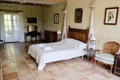 a bedroom with a white bed and a chair at La Bomba Is A Stunning Farmhouse in Glorious Countryside With Private Pool in Saint-Paulet