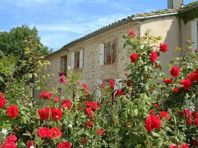 a building with red flowers in front of it at La Bomba Is A Stunning Farmhouse in Glorious Countryside With Private Pool in Saint-Paulet