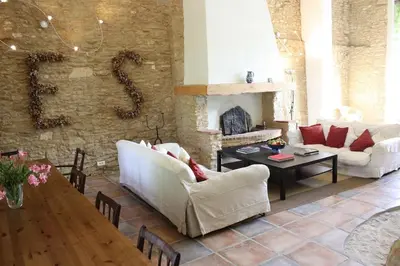 a living room with white furniture and a stone fireplace at La Bomba Is A Stunning Farmhouse in Glorious Countryside With Private Pool in Saint-Paulet