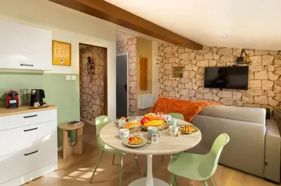 a bedroom with a large bed and a stone wall at Cap color-Parking public gratuit-4 guests-centre-ville in Limoux