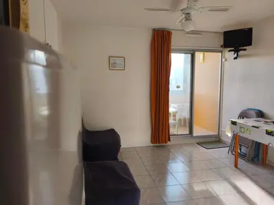 a living room with a couch and a table and a window at Appartement T2 à Gruissan - Piscine & Parking, 2/3 Pers. - FR-1-796-107 in Gruissan
